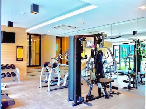 a gym with several treadmills and exercise machines at KensingtoN Laemchabang-Sriracha, Special rate for monthly rent, Cozy Style of Living and near Kasetsart University in Ban Ao Udom