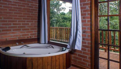 a bath tub in a room with a window at Espaço Recanto do Pico in Santo Antônio do Pinhal