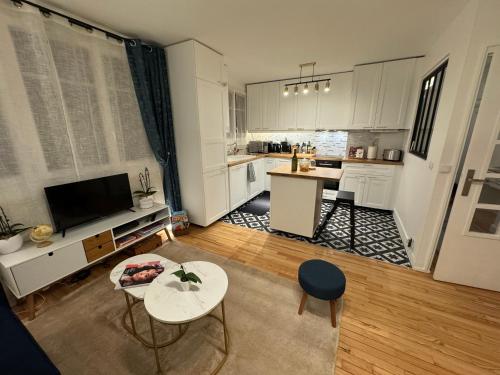 une cuisine avec des placards blancs et une table et des chaises blanches dans l'établissement Premium Apartment ! 30 min - Paris & DisneyLand - Family Friendly & Parking, à Champigny-sur-Marne