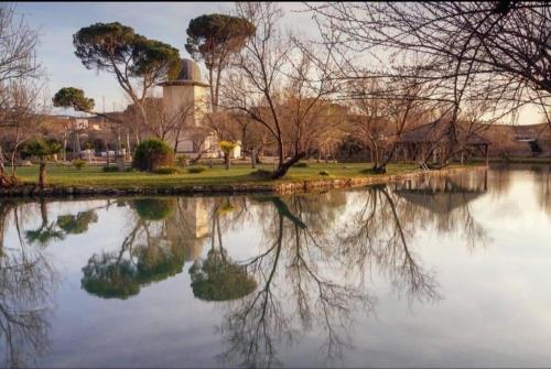 a reflection of a building in a body of water at Apartamentos Buganvilla in Alhama de Aragón