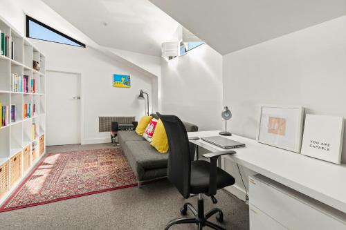 雪梨的住宿－4 bedrooms family home in Bronte，一个带书桌和沙发的家庭办公室