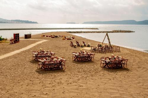 a group of tables and chairs on a beach at W Costa Navarino in Pylos