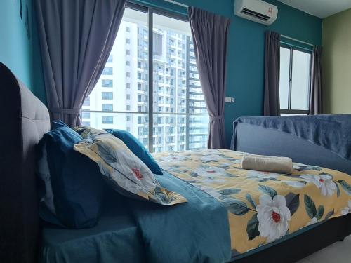 a bedroom with a bed with a floral blanket and a window at Great Escape by SM Retreats in Cyberjaya