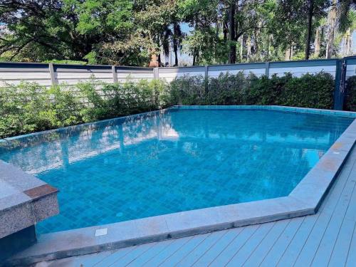 a swimming pool with blue water and a fence at 一室一厅宁静舒适公寓清迈市中心 in Chiang Mai