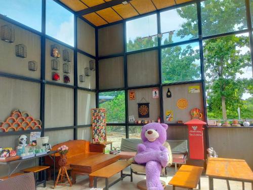 a purple teddy bear sitting on a table in a room at innbox Chiangmai Hotel in Ban Si Ngam