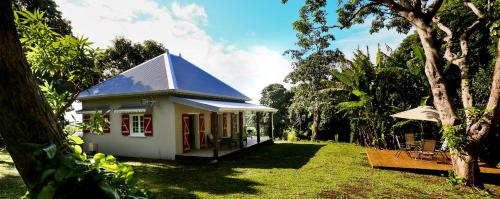 a small house with a blue roof in a yard at Les Terrasses de Niagara in Sainte-Suzanne