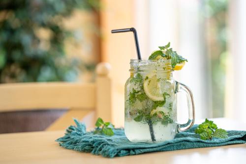 a mason jar filled with a drink with a straw at Coral Beach Resort Sharjah in Sharjah