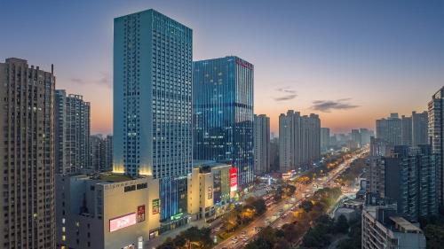 a city skyline with tall skyscrapers at night at Holiday Inn Express Changsha Development Zone, an IHG Hotel in Xingsha