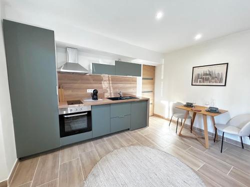 une cuisine avec des armoires bleues et une table et des chaises dans l'établissement AirGarden - 1 à 2 Personnes - Cancéropôle, à Toulouse