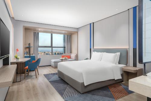 a hotel room with a bed and a desk at Holiday Inn Express Changsha Development Zone by IHG in Xingsha