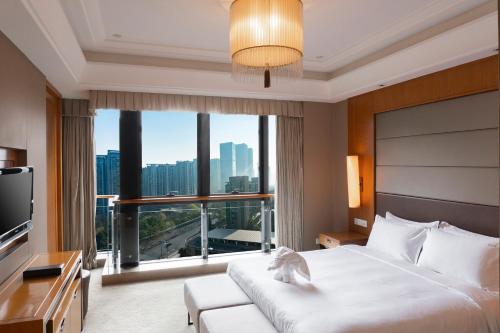um quarto de hotel com uma cama e uma grande janela em Holiday Inn Hangzhou CBD, an IHG Hotel em Hangzhou