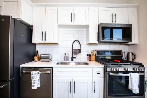 a kitchen with white cabinets and a stainless steel appliances at Mountain View Chalet at The Quarry - Sleeps 6! in Whitefish