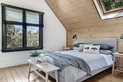 ein Schlafzimmer mit einem Bett und einer Holzdecke in der Unterkunft Wondernest, Blue Mountains in Blackheath
