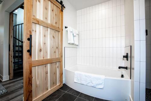 a bathroom with a white tub and a wooden door at Mountain View Chalet at The Quarry - Sleeps 6! in Whitefish