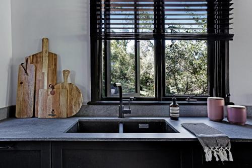 eine Küche mit einem Waschbecken und einem Fenster in der Unterkunft Wondernest, Blue Mountains in Blackheath