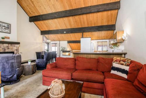 a living room with a red couch and wooden ceilings at Broomall at Snow Summit Ski Resort in Big Bear Lake