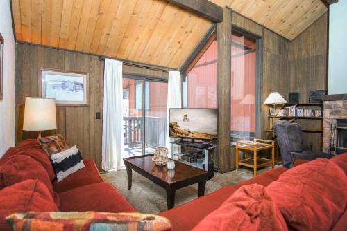 a living room with a red couch and a tv at Broomall at Snow Summit Ski Resort in Big Bear Lake