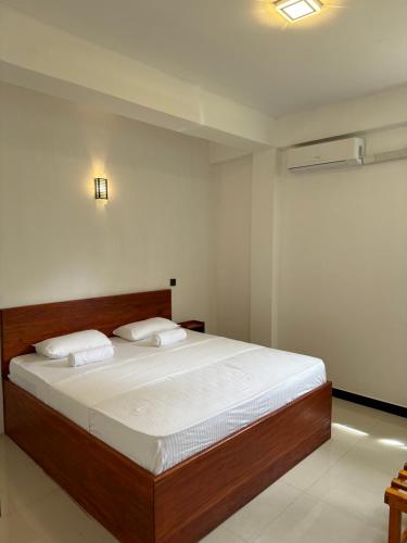 a bedroom with a large bed with white sheets at Sky Heaven Hotel in Kandy