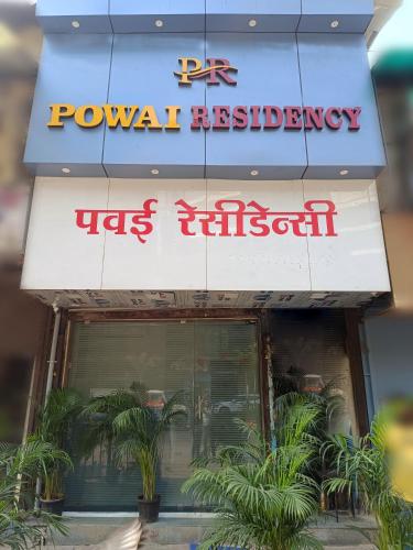 a sign for a restaurant with plants in front of it at Hotel Powai Residency in Mumbai