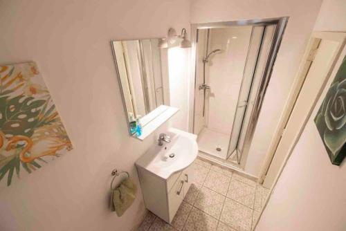 y baño blanco con lavabo y ducha. en Harbour view, en Senglea