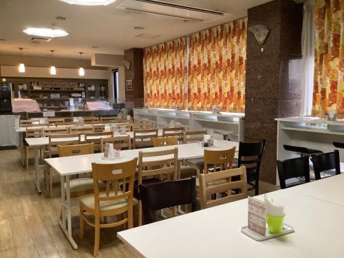 a dining room with tables and chairs and a cafeteria at Hotel Crown Hills Nakamura in Shimanto