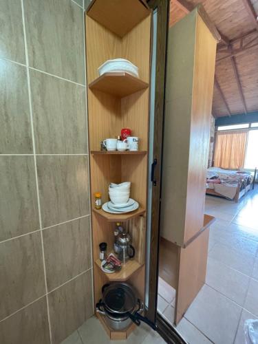 a bathroom with a shower and a shelf with dishes at Studio with view in Polis area in Paphos