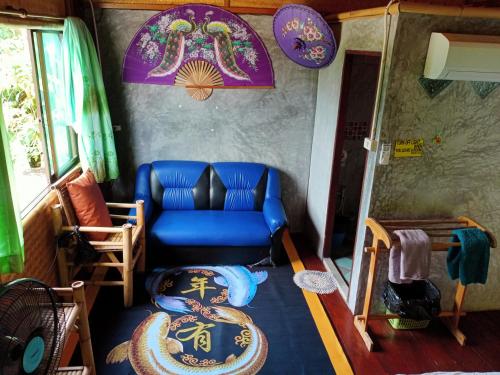 a living room with a blue couch and a table at Comon Bungalow HaadChaoPhao in Haad Chao Phao
