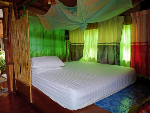 a bedroom with a bed with a canopy at Comon Bungalow HaadChaoPhao in Haad Chao Phao