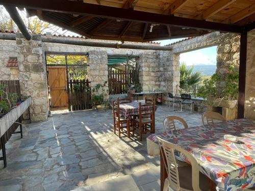 a patio with a table and chairs on a stone wall at Studio with view in Polis area in Paphos City