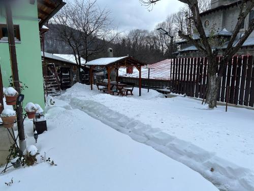 a yard covered in snow next to a house at La Casa Verde in Buşteni