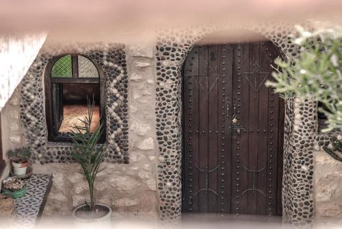 a model of a house with two doors and a mirror at Dar Afoulky Maison D'hotes in Sidi Kaouki