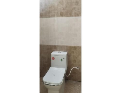 a bathroom with a white toilet in a room at The Ramagya Hotel, Chitrakoot in Sītāpur Mūāfi