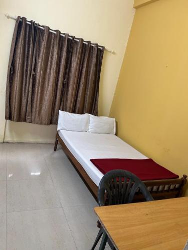 a small bed in a room with a window at Mukalel Tourist Home in Ernakulam