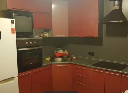uma cozinha com armários vermelhos e um lavatório em VIP apart 794 em Tbilisi