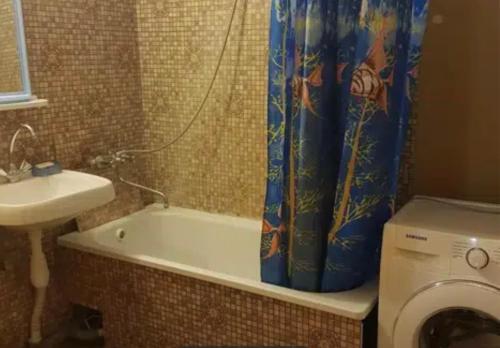 uma casa de banho com uma cortina de chuveiro e uma máquina de lavar roupa em VIP apart 794 em Tbilisi
