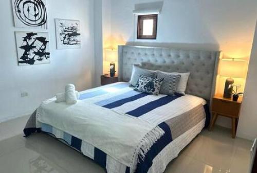 Schlafzimmer mit einem Bett mit blauer und weißer Bettwäsche in der Unterkunft KASA The Lofts 305 in San Juan