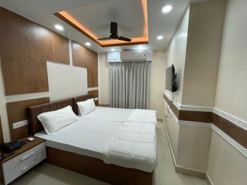 Schlafzimmer mit einem Bett und einem Deckenventilator in der Unterkunft Hotel Nandan Inn in Gaya