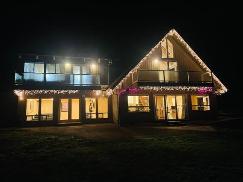 a house lit up at night with lights at Lake Tapps Dock House on the Bankers Island in Dieringer