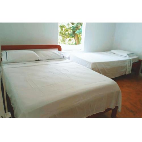 duas camas sentadas uma ao lado da outra num quarto em Posada Campestre en Doradal em Puerto Triunfo