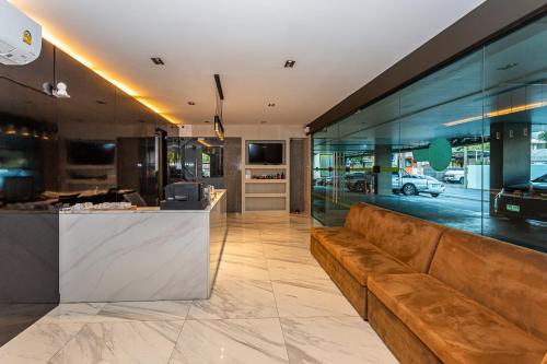 a lobby with a brown couch and a counter at Infinite Hotel-Ratchada in Bangkok