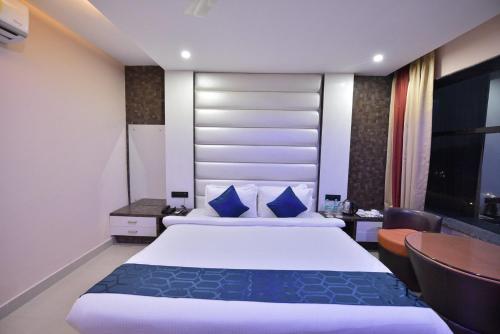 a hotel room with a large bed and a desk at Hotel Himalaya in Bongaigaon