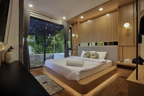 a bedroom with a large bed and a large window at Yama Onsen Villa in Bandung