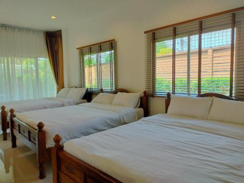 three beds sitting in a room with windows at Private house Casa seaside Rayong in Ban Chak Phai