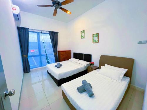 a bedroom with two beds and a ceiling fan at Haiya homestay Imago Shopping Mall 海雅民宿Imago购物 广场 in Kota Kinabalu