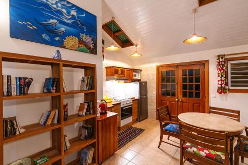 a kitchen with a table and a dining room at Heimanarii's Lodge - Fare Opuhi in Haapiti