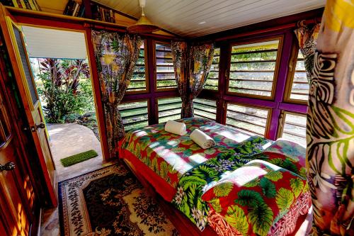 a bedroom with a bed in the back of a train at Heimanarii's Lodge - Fare Opuhi in Haapiti