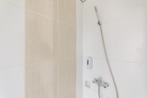 y baño con ducha con cabezal de ducha. en Sans Hotel Green Bekasi by RedDoorz, en Bekasi