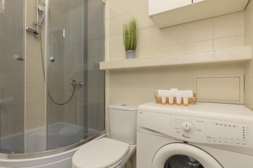 a bathroom with a washing machine and a shower at Rent like home - Comfortable Studio Sapiezynska in Warsaw