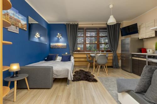 a bedroom with a bed and a blue wall at Rent like home - Comfortable Studio Sapiezynska in Warsaw