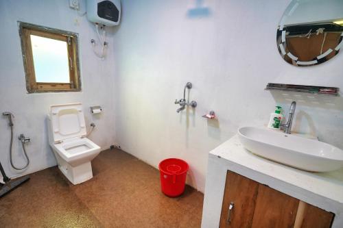uma casa de banho com um lavatório branco e um WC. em Dharti The Glamping Haven em Darjeeling
